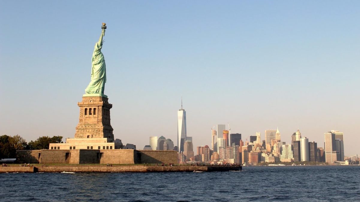 person taking photo of Statue of Liberty