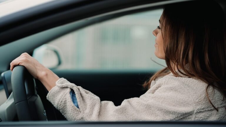 woman in gray hoodie sitting inside car during daytime