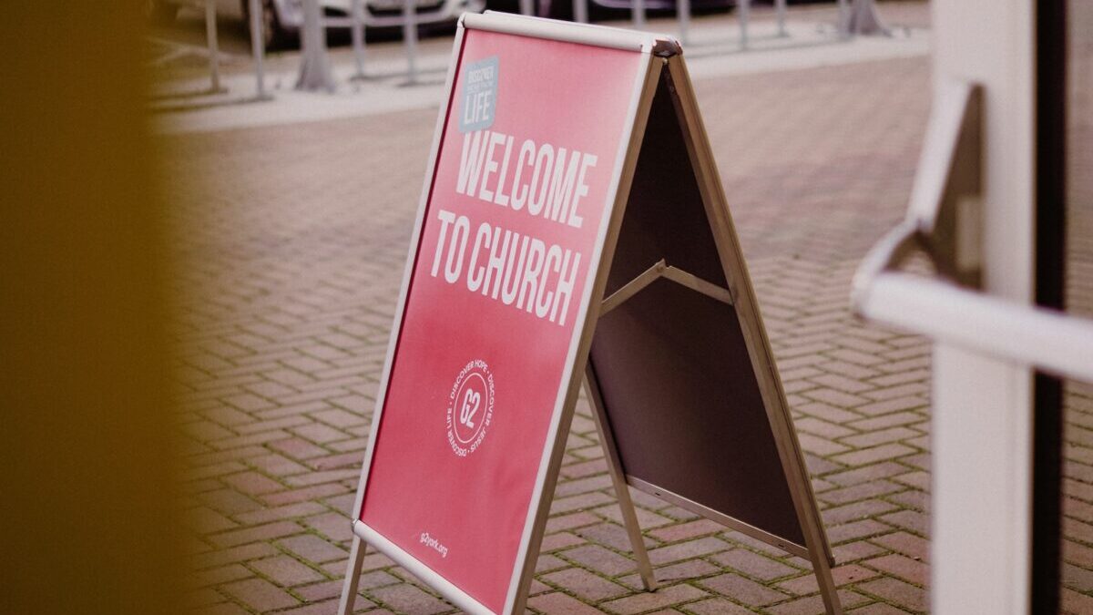 a welcome to church sign in front of a building