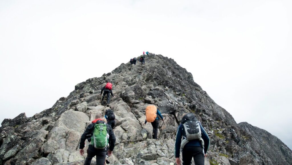 climbers hiking through mountain peak during daytime