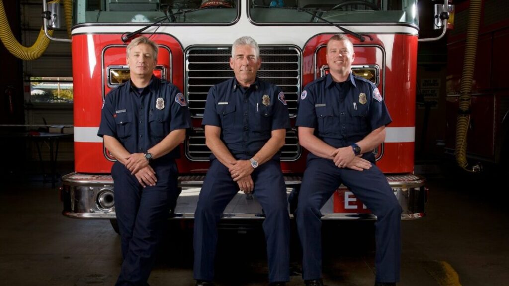 2 men in blue and red polo shirt sitting on red bus