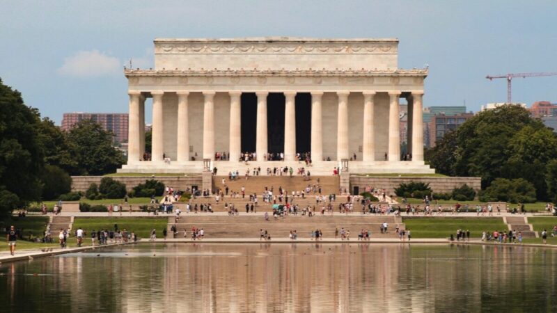 a group of people standing in front of the lincoln memorial