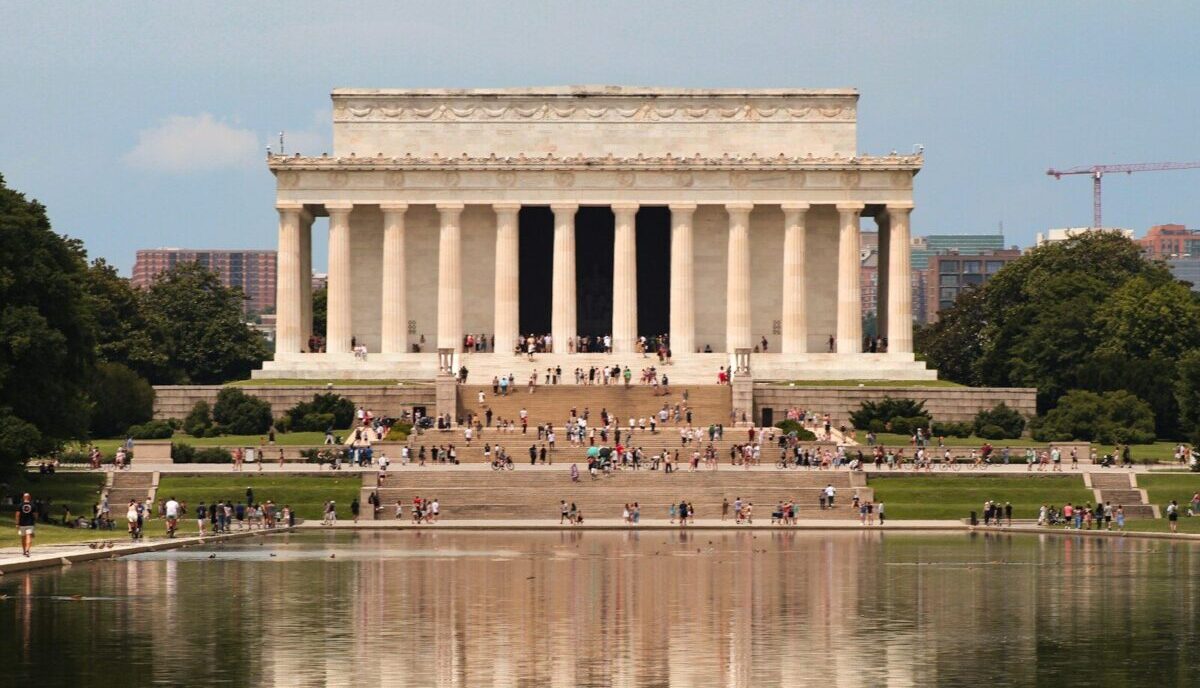 a group of people standing in front of the lincoln memorial